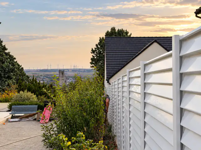 Côté voisin, la clôture ; en face, la vue sur Auxerre au coucher du soleil