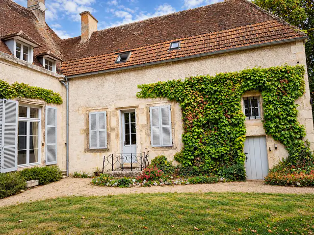 Façade sur cour : la vigne vierge tenue à distance des volets et de la gouttière